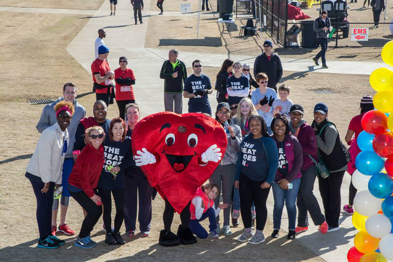 people standing with a heart-shaped mascot