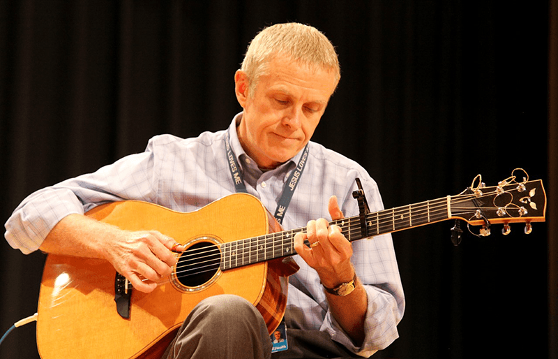 man playing guitar on stage