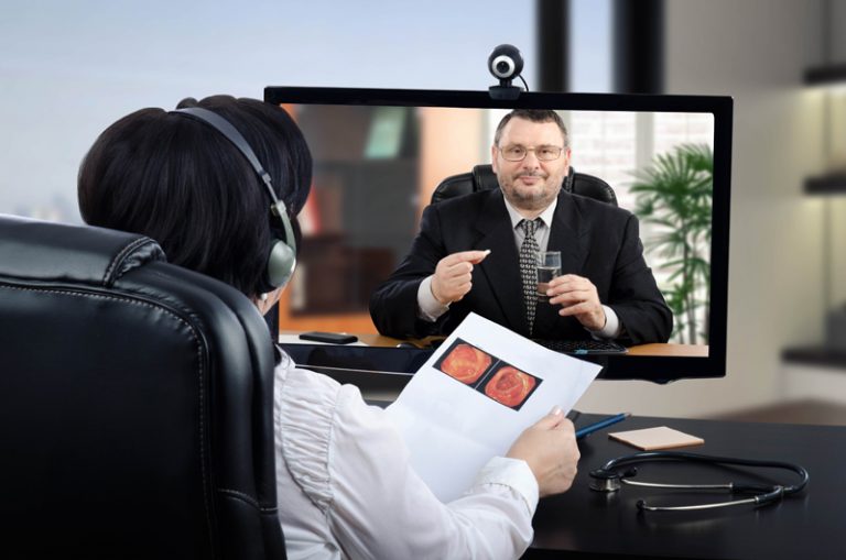 doctor speaking to man on computer