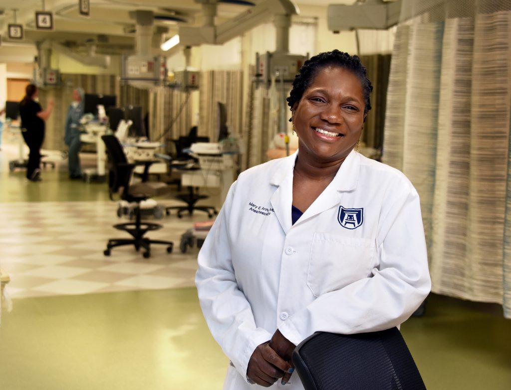 A female doctor wearing a lab coat and smiling.