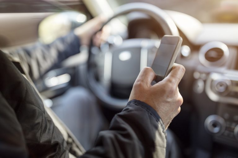 person driving with a cellphone out