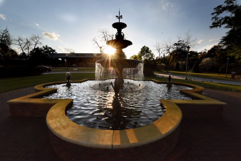 the sun going down on a fountain