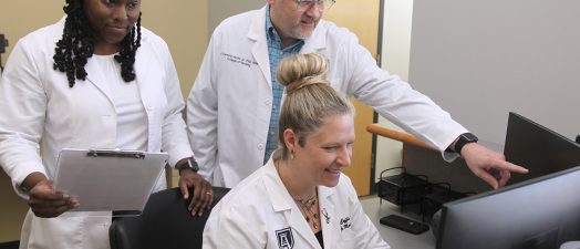 three people looking at a computer