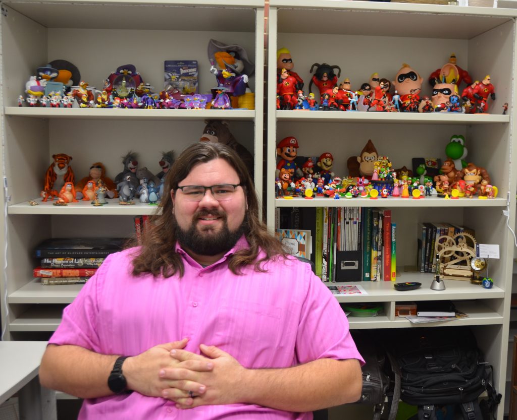 man sitting in front of action figures