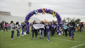 A picture of a team holding a banner during the Unite in the Fight Against Cancer walk.