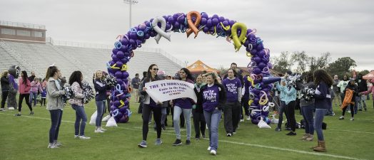 A picture of a team holding a banner during the Unite in the Fight Against Cancer walk.