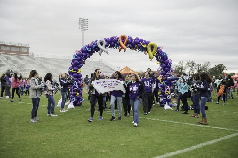 A picture of a team holding a banner during the Unite in the Fight Against Cancer walk.