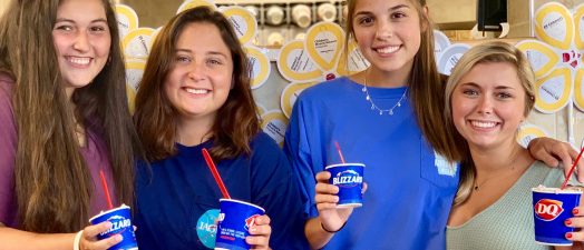 Four women posing with Dairy Queen Blizzards.