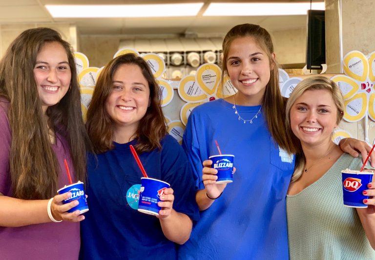 Four women posing with Dairy Queen Blizzards.