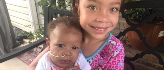 girl holding baby sister