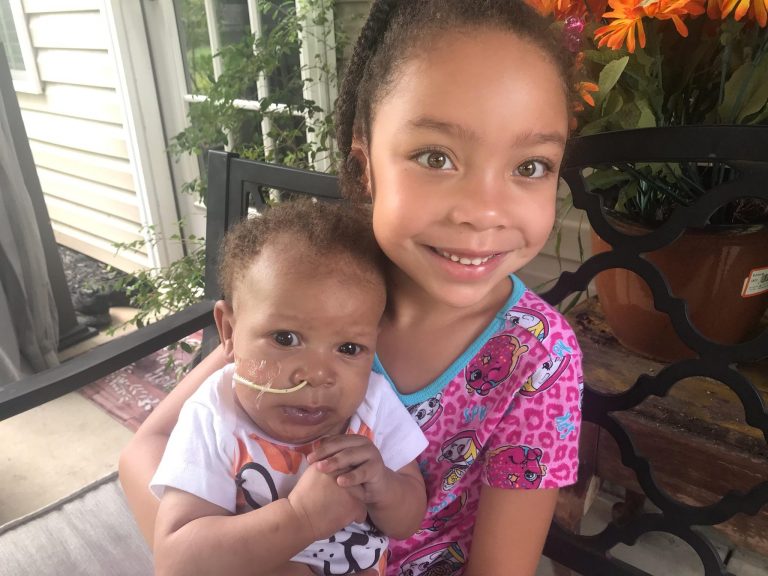 girl holding baby sister