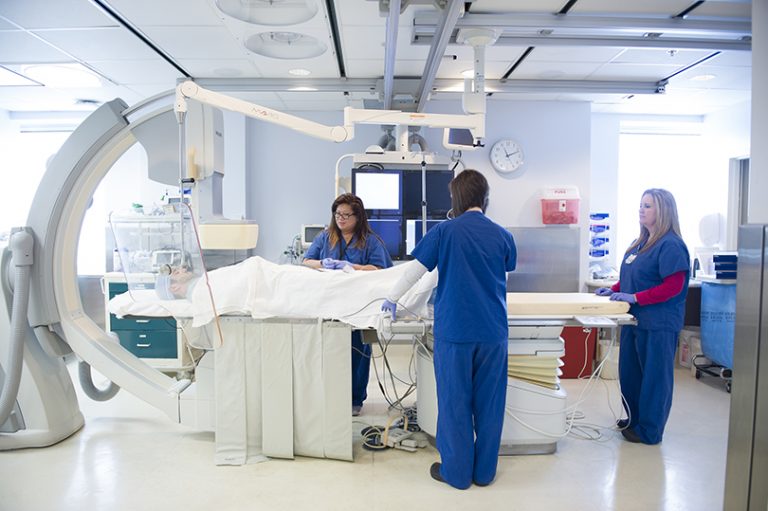 three nurses helping a patient in a lab