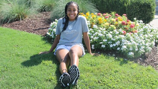 Girl sitting in front of flowers
