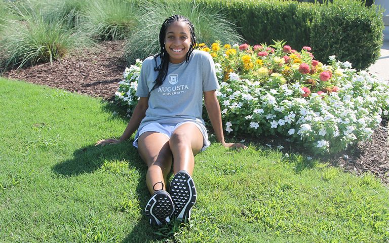 Girl sitting in front of flowers