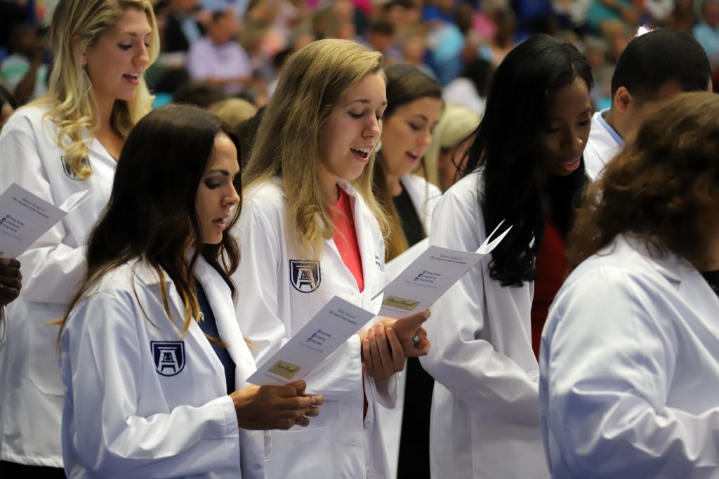 People in white coats reading