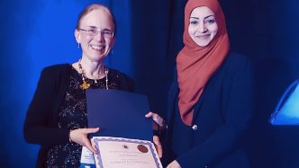 two women holding an award