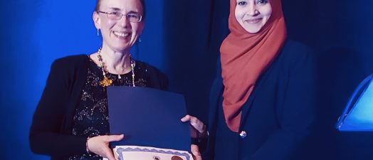 two women holding an award