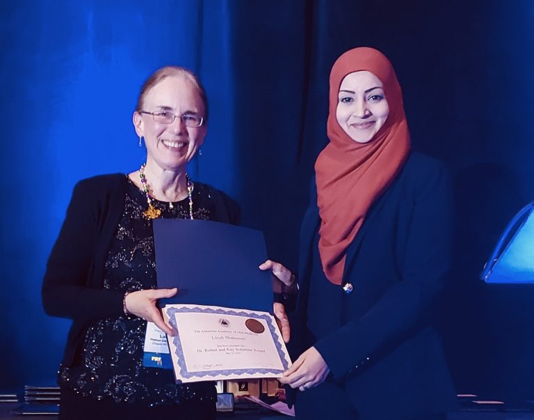 two women holding an award