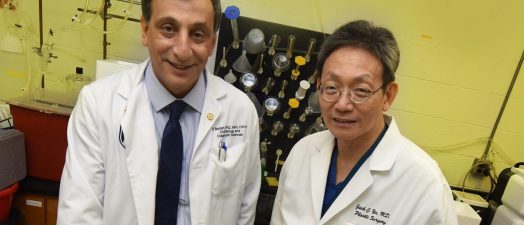 two doctors standing in front of lab equipment