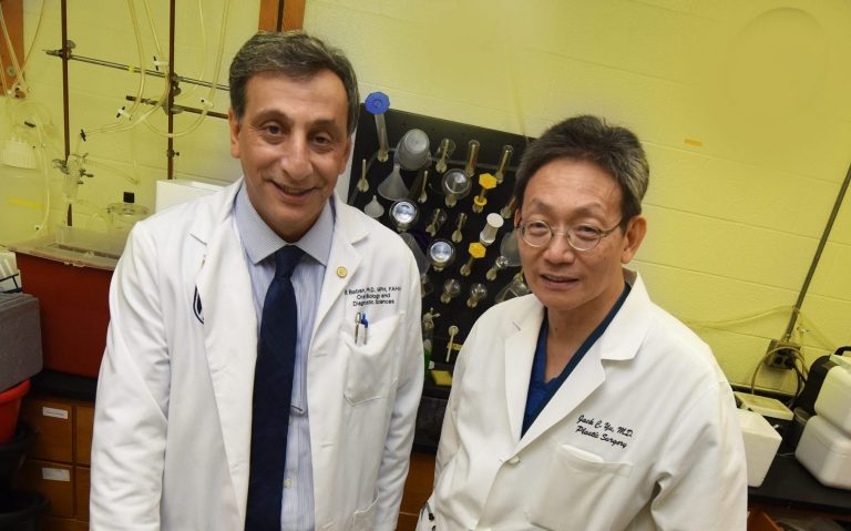 two doctors standing in front of lab equipment