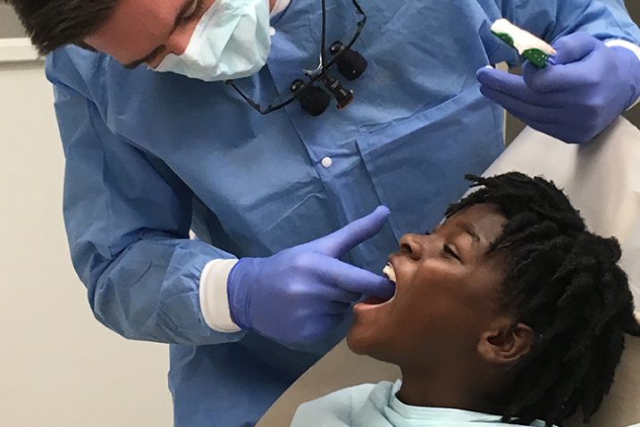 Dental student checking a youth's mouth