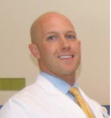 A photo of a man in a white lab coat.