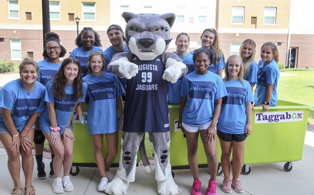 Mascot posing with students.