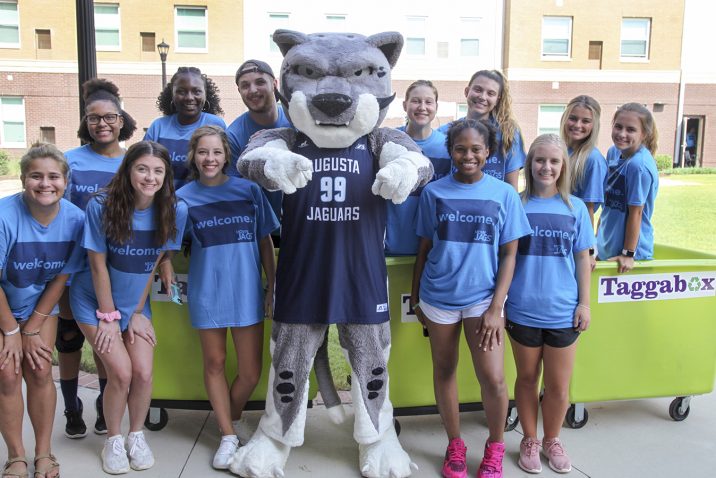 Mascot posing with students.