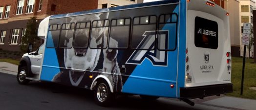 Color photo of Augusta University shuttle with mascot Augustus and the athletic A