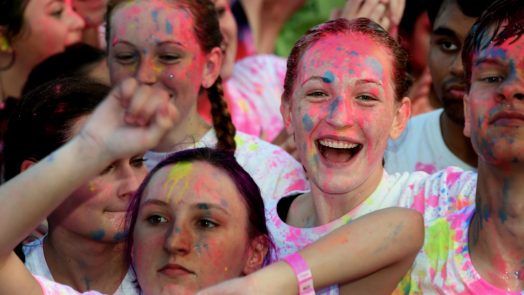 A group of girls smiling with paint on their faces.