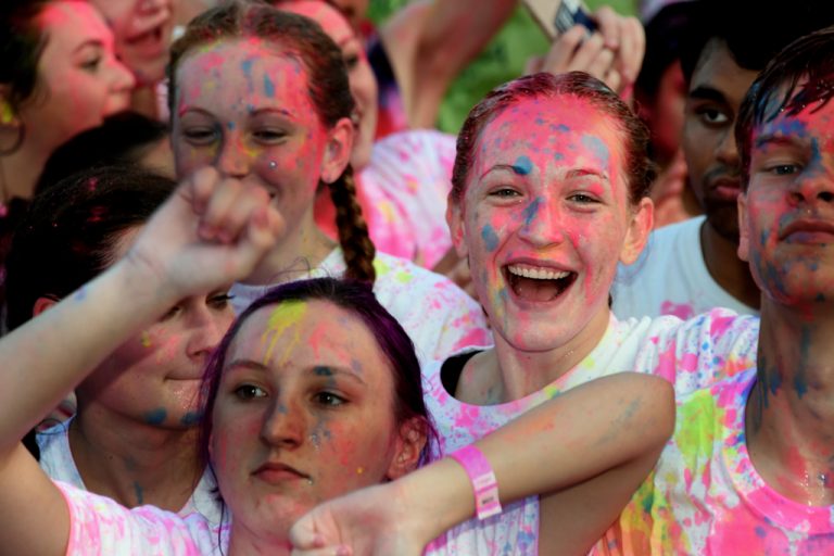 A group of girls smiling with paint on their faces.