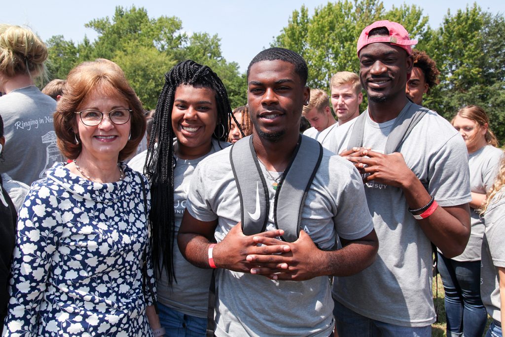 Woman standing with students. 