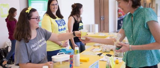 people handing out lemonade at their lemonade stand