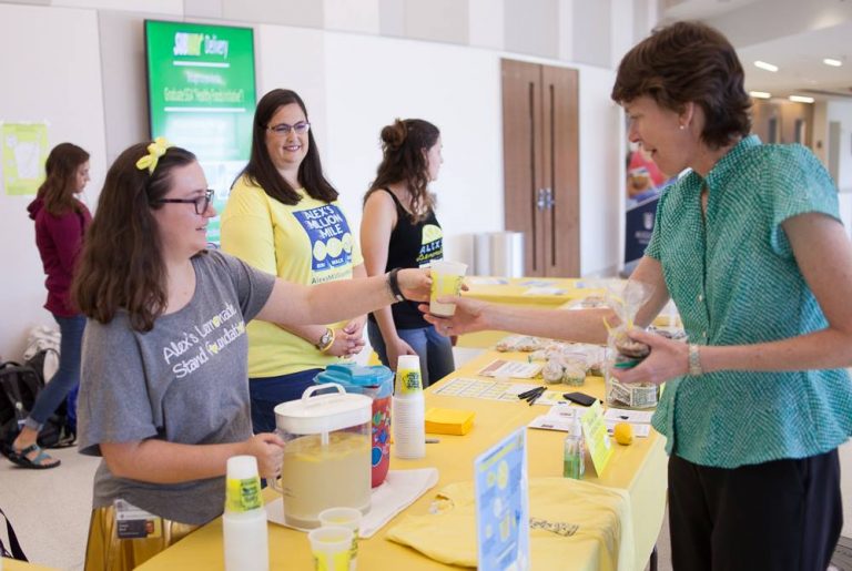 people handing out lemonade at their lemonade stand