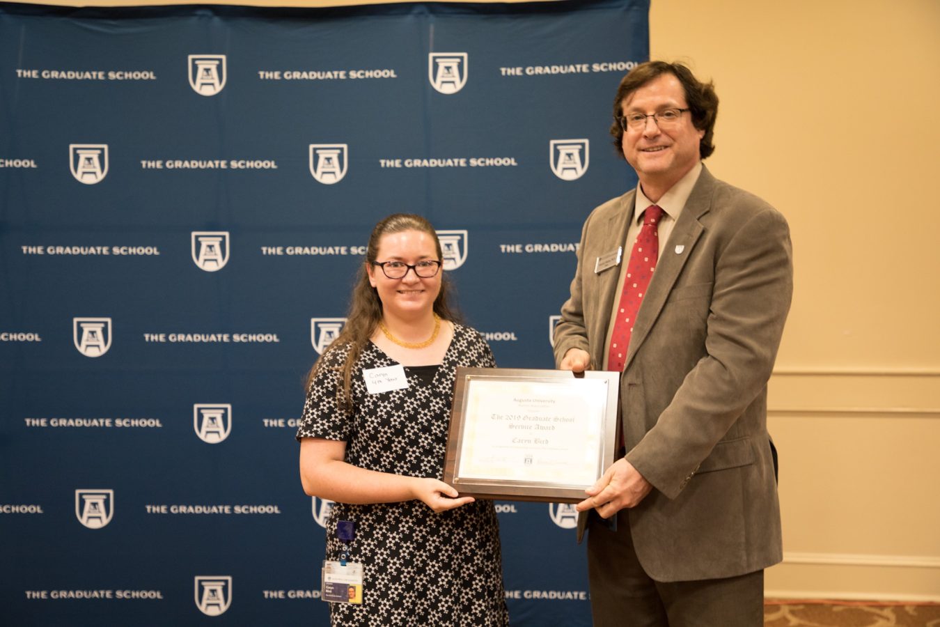 two people holding an award 