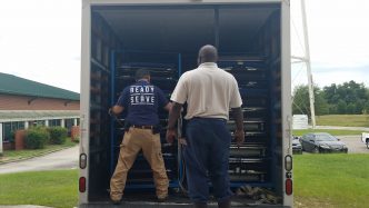 two men unloading truck full of supplies