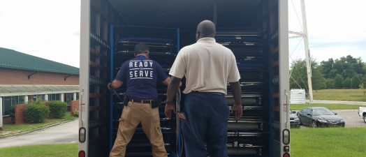 two men unloading truck full of supplies
