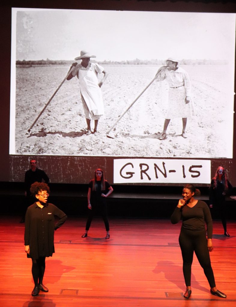 Actors on stage with a photo.