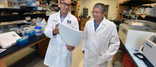 two doctors talking in the lab with paperwork