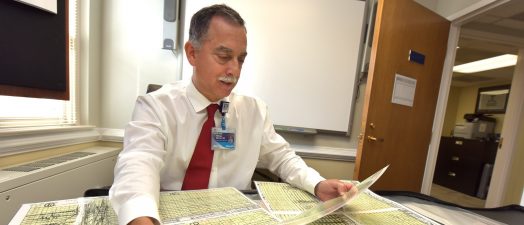 doctor sitting at desk looking through papers