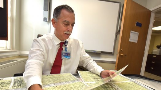 doctor sitting at desk looking through papers