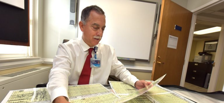 doctor sitting at desk looking through papers