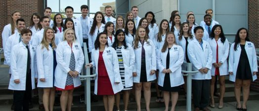 group photo of students with white coats