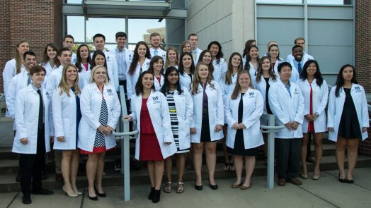 group photo of students with white coats