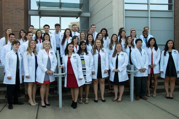 group photo of students with white coats
