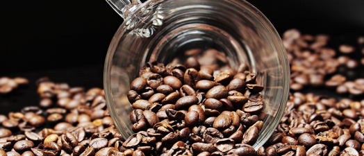 A cup surrounded by coffee beans.