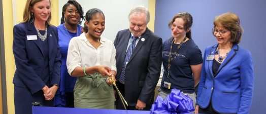 group photo of people cutting a large ribbon