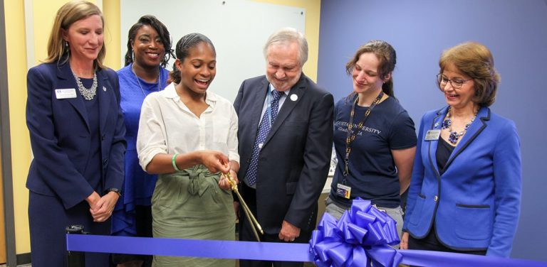 group photo of people cutting a large ribbon