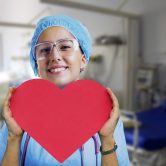 A nurse holding a heart-shaped paper.