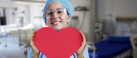 A nurse holding a heart-shaped paper.